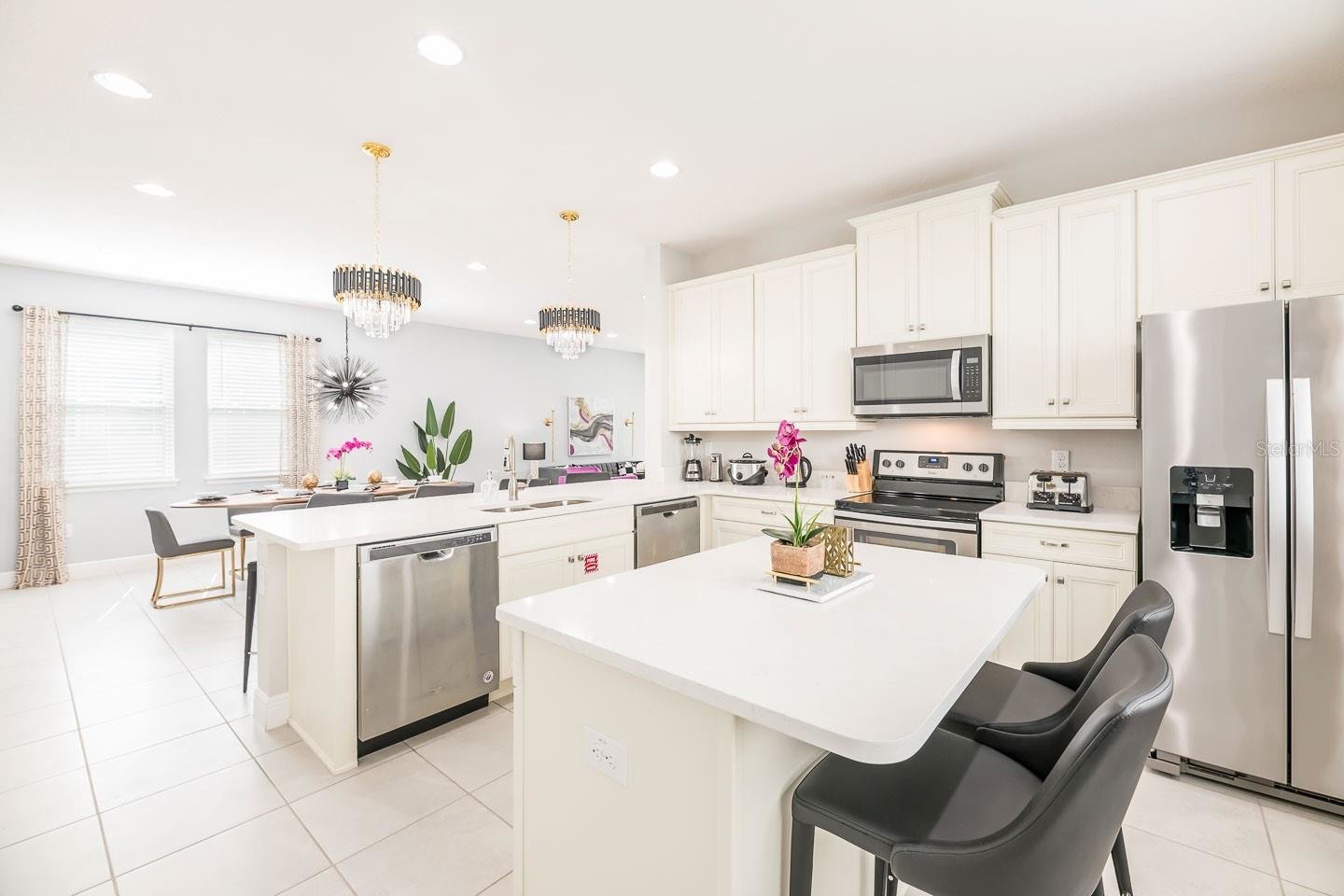 bright white kitchen with modern stainless steel appliances